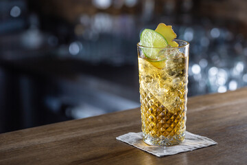 Bourbon and ginger lemonade served with ice in a glass on a bar