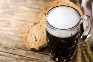 Traditional kvass beer mug with rye bread on wooden table. Copy space	