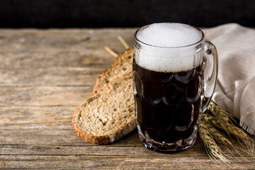 Traditional kvass beer mug with rye bread on wooden table. Copy space	
