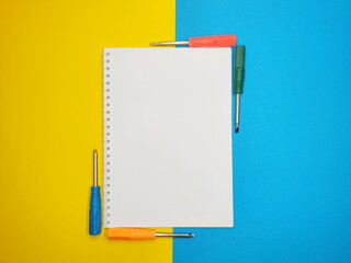 vertical notepad with colored screwdrivers in the corners