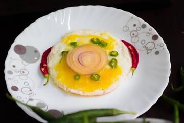 Food, Bulls eye, egg garnished with chilly and onion, looks yummy, tasty. garnished with cutting table, knife and spoon in background.