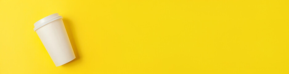 Simply minimal design paper coffee cup on yellow colorful trendy background. Takeaway drink container. Good morning wake up awake concept Template of drink mockup. Flat lay top view copy space banner