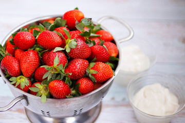 Organic strawberry and whipped cream in glass bowls.