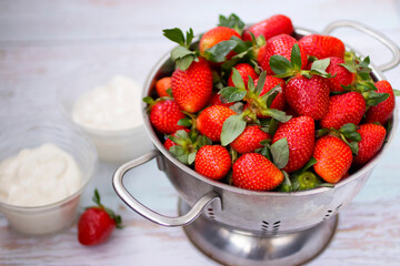 Organic strawberry and whipped cream in glass bowls.