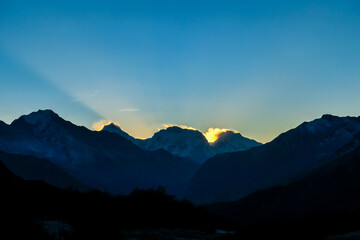 A soft and early sunset in the nearby of Thorung La Pass, Annapurna Circuit Trek, Nepal. Harsh and barren landscape around. Clear and blue sky. High Himalayan ranges in the back. Snow capped mountains