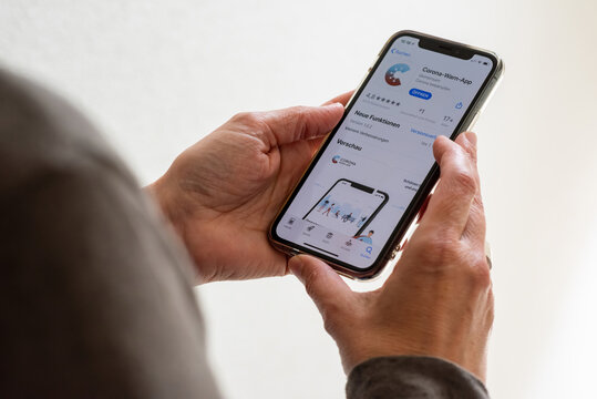 Ostfildern, Germany - June 16, 2020: A middle aged woman is about to download the new smartphone app to combat the corona pandemic on her Apple iPhone 11 Pro. The app is comissioned from the German