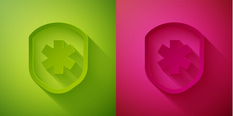Paper cut Medical shield with cross icon isolated on green and pink background. Protection, safety, password security. Paper art style. Vector Illustration