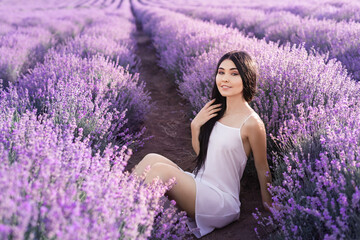 Beautiful girl on the lavender field. Beautiful woman in the lavender field on sunset.Beautiful healthy hair. Young teen girl brunette with long shiny hair over lavender field in Provence. 