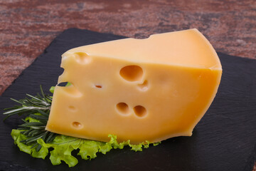 Maasdam cheese  in the board served salad leaves