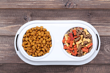 Dry pet food in bowl on brown wooden table