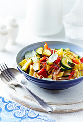 Pappardelle Pasta with Vegetables and fresh Basil on bright wooden Background.