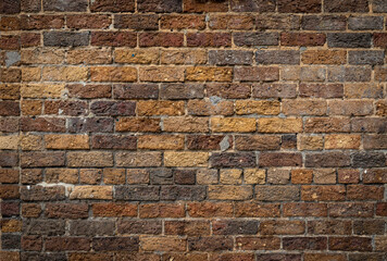 Mixed rustic brick background, rough texture backdrop in shades of brown and yellow ochre, creative copy space, horizontal aspect