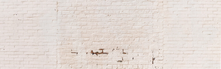 Mixed brick painted white panorama background, peeling paint areas, creative copy space, horizontal aspect