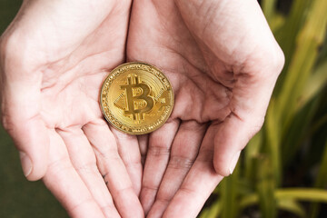 Bitcoin coin in a woman's hands