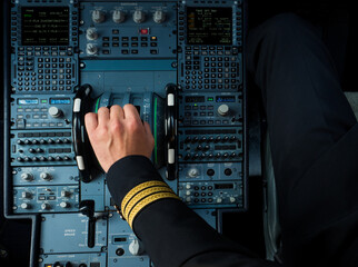 Captain hand accelerating on the throttle in commercial airplane