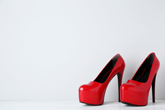 Red high heel shoes on grey background