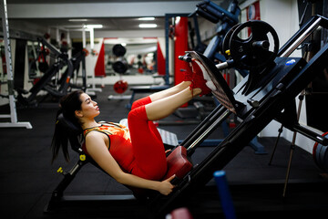 Girl in the gym. Goes in for sports, on exercise machines
