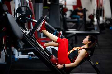 Girl in the gym. Goes in for sports, on exercise machines