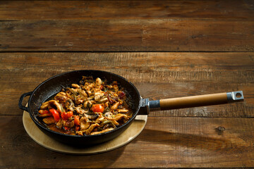 Frying pan with chicken and vegetables in Thai sauce.