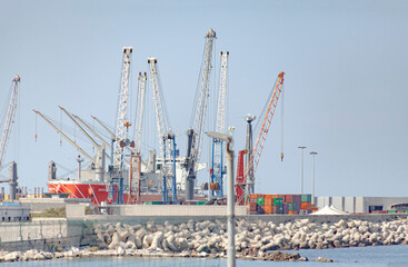Fototapeta na wymiar Containers, cranes and cargo ships at the port of Bari, Italy, on a clean day. 