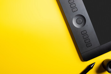 top view of modern drawing tablet and black stylus on yellow