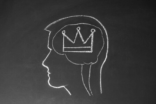 Concept narcissistic man. The male head and crown are drawn on a chalk board.