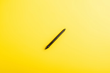 top view of black stylus isolated on yellow
