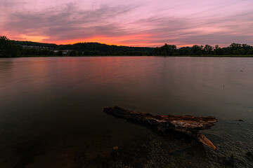 Colourful sunset with reflections in the pond in the natural park Eijsder Beemden (english Eijsder Beemden) along the river Meuse. Wild horses and galloway are part of the ecology system in this area