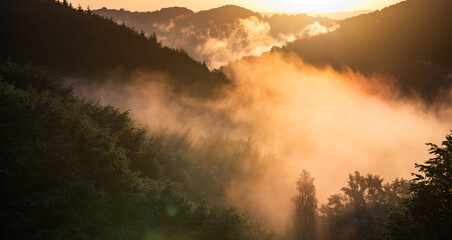 Fototapeta premium epic summer panorama of foggy sunset in mountains