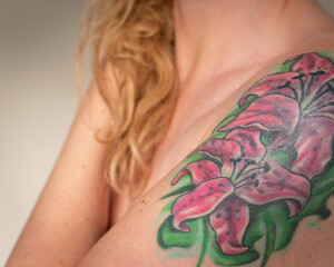 pink flower tattoo on woman's arm 