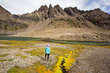A colorful stream and an unidentified hiker in Dientes De Navarino trek, Navarino island, patagonia...