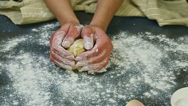 slow motion closeup of woman hands form ball from little piece of yeast dough
