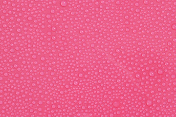 Little water drops on pink bright background macro