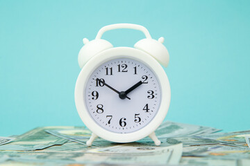 Close-up of alarm clock and money on blue background. Business Finance and Money concept. Save...