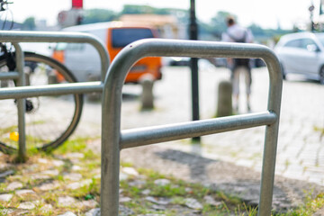 Mounts for bicycles in a pedestrian  area with a bicycle in the background
