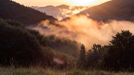 epic summer panorama of foggy sunset in mountains