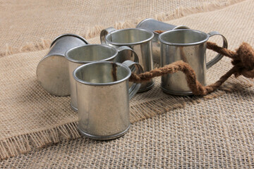 Vintage steel cups for cold vodka on linen fabric background. Before drinking the vodka, the cups is cooled in refrigerator.