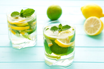 Water detox with lemon, lime and mint on a blue background.