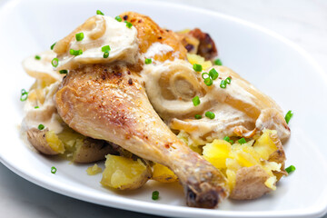 chicken leg on creamy onion sauce with potatoes