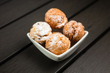 Small round cookies covered in powdered sugar in a white bowl