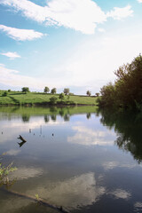 Beautiful river in the highlands in summer. Lake in an ecologically clean park reserve on a background of hills. A pretty landscape in the spring. Stock photo for design