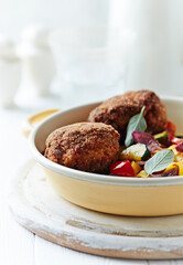 Fried Breaded Meatballs with Pappardelle Pasta, Vegetables and fresh Basil on bright wooden Background. Close up. 