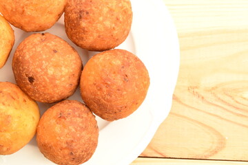 Fresh aromatic, cheese donuts, close-up, on a ceramic plate, on a wooden table.