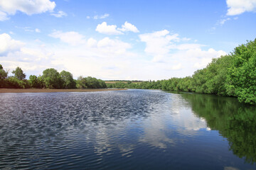 Beautiful river in the highlands in summer. Lake in an ecologically clean park reserve on a background of hills. A pretty landscape in the spring. Stock photo for design