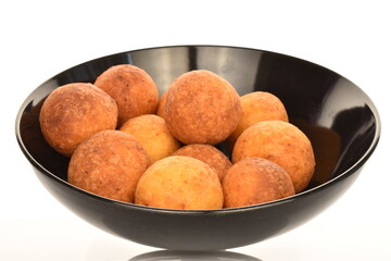 Fresh aromatic, cheese donuts in a black ceramic plate, close-up, on a white background.