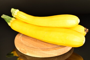 Fototapeta na wymiar Fresh ripe, bright yellow zucchini, close-up, on a black background.