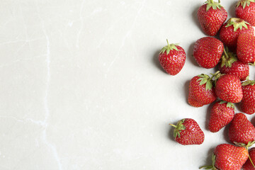 Delicious ripe strawberries on light grey marble table, flat lay. Space for text