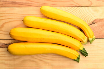 Fototapeta na wymiar Fresh ripe, bright yellow zucchini, close-up, on a white wooden table.
