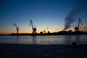 Obraz premium Cranes at Stenpiren at sunset in Gothenburg, Sweden