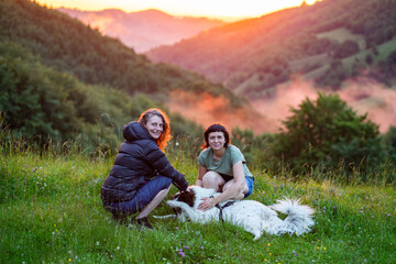 woman and dog in amazing summer landscape at sunset